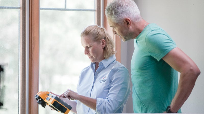 Man and woman checking energy measuring device