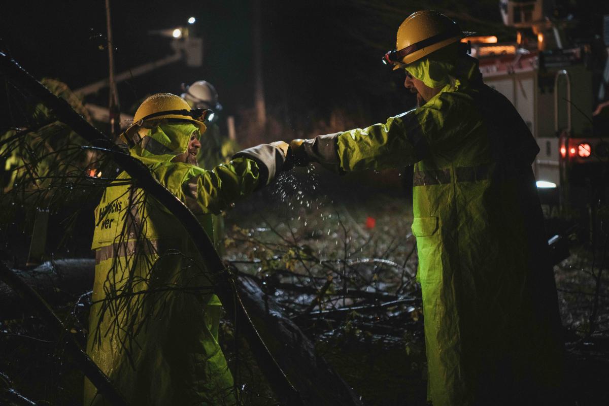 Two lineworkers fist bumping