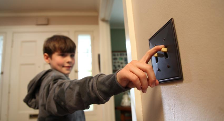 Boy going to turn off a light