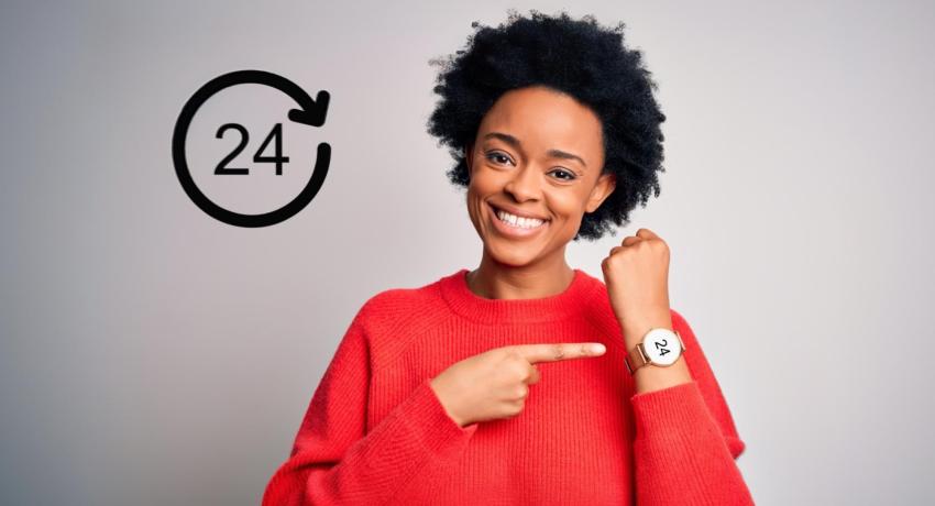 Woman pointing to her wrist watch; watch face says 24.