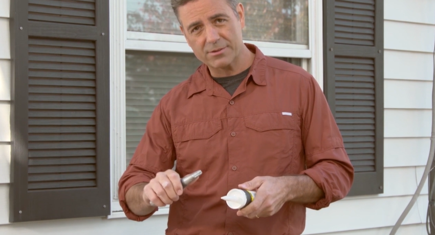 Photo of man caulking window