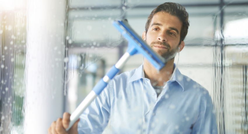 Photo showing man cleaning window