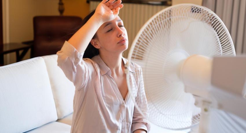 woman cooling off with fan