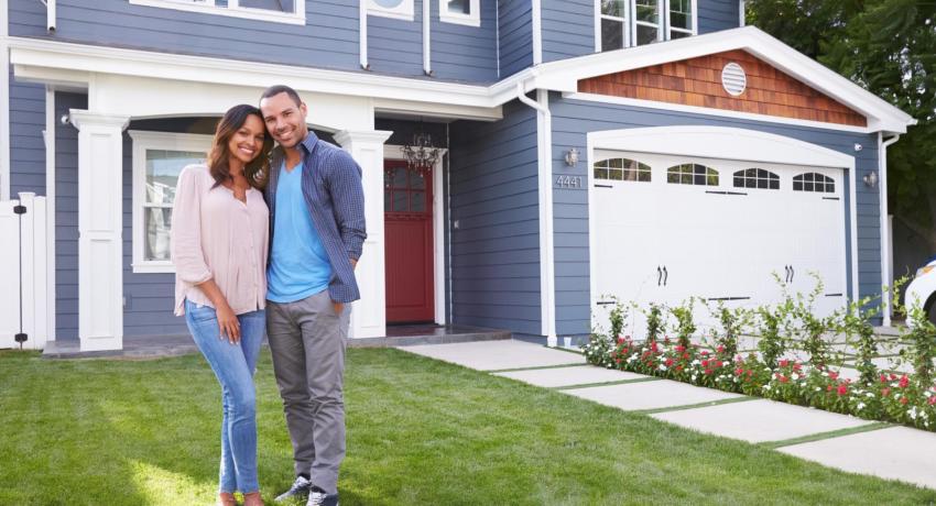 Photo of man and woman standing on lawn in front of a house