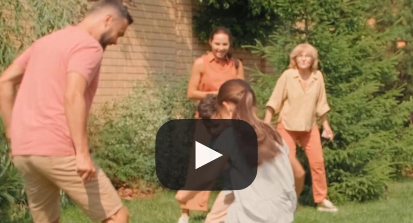 Photo of family playing soccer in garden