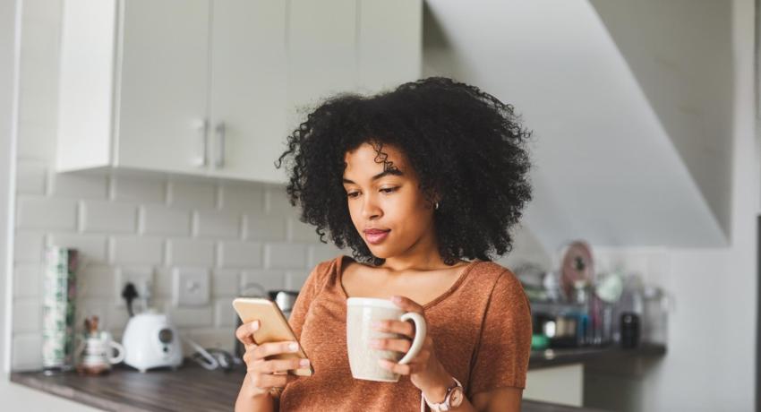 woman reading phone in kitchen
