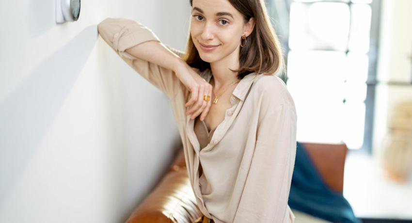 Photo of woman next to a smart thermostat