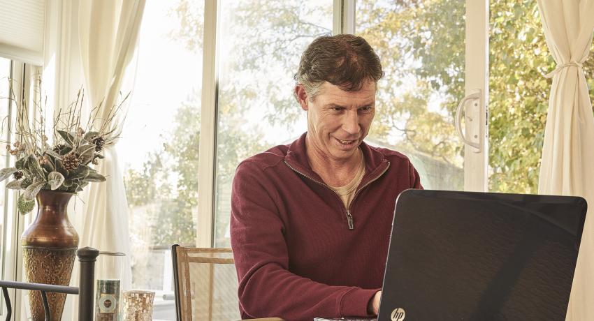 Man sitting at home working on laptop computer
