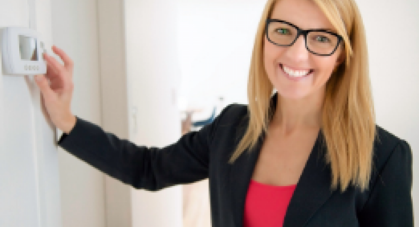 Photo showing woman adjusting thermostat
