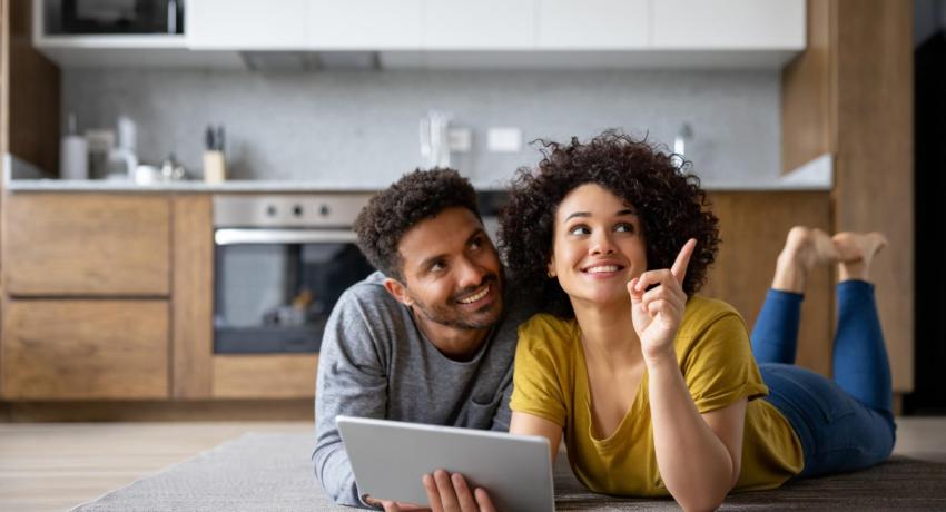 Couple planning a remodel on laptop on floor
