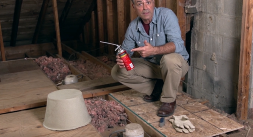 Man in attic holding spray can