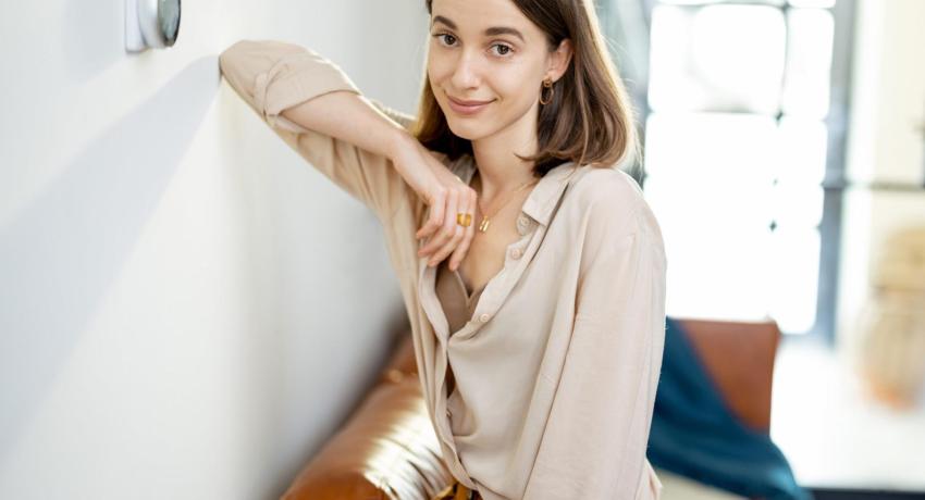 Photo of woman next to a smart thermostat