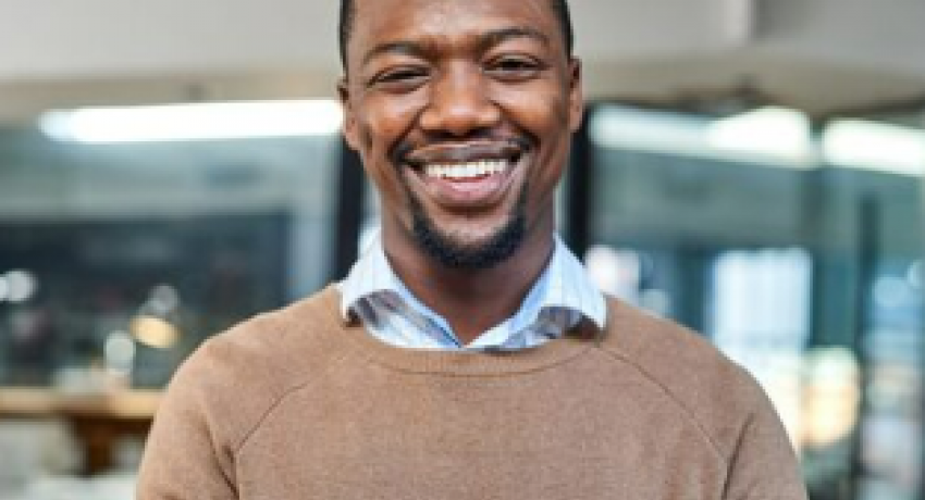 Photo of smiling man in front of office background.