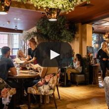 Photo of the inside of a restaurant, showing people talking