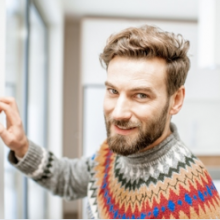 Man smiling and adjusting thermostat