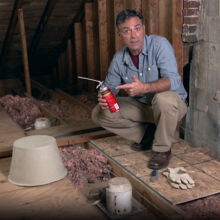 Man in attic holding spray can