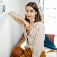 Photo of woman next to a smart thermostat